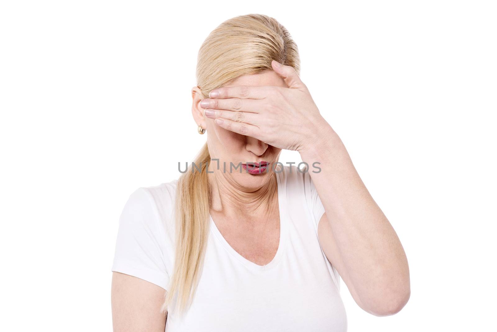 Woman covering eyes with her hand