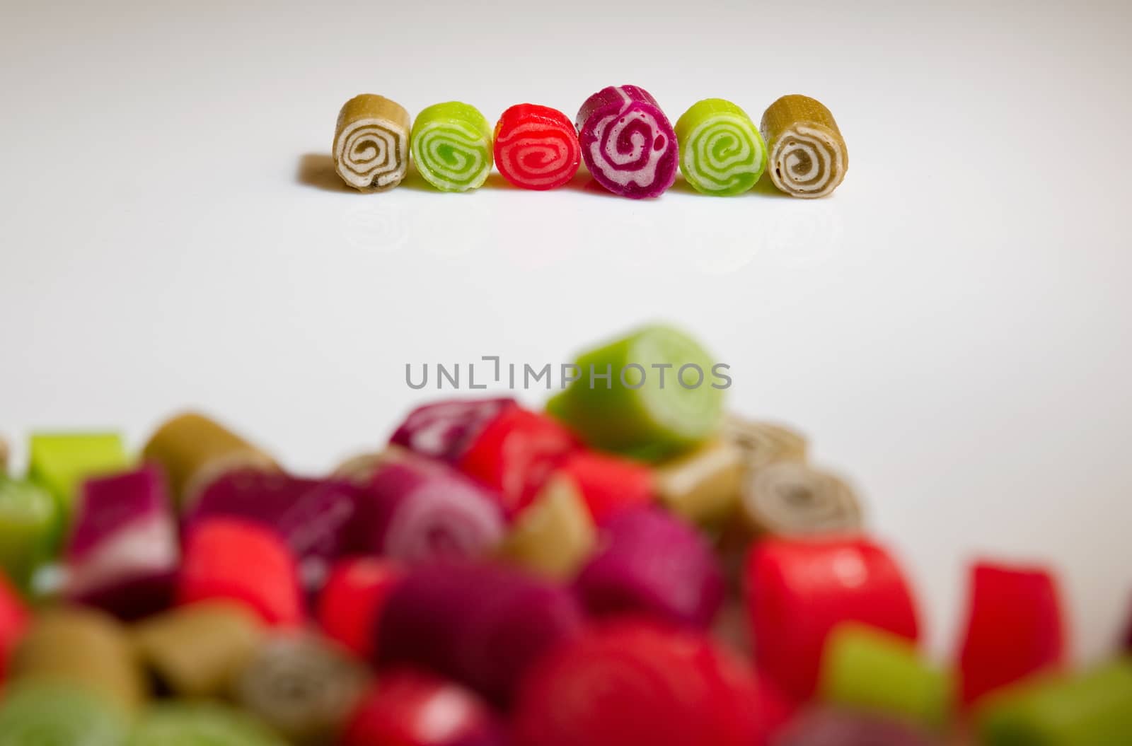 Colorful candies on white background by anderm