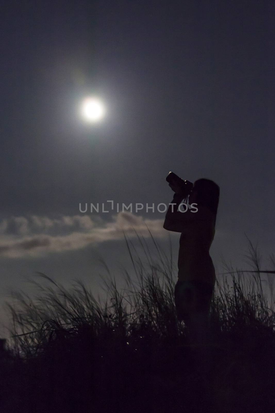 Female photographer under moon