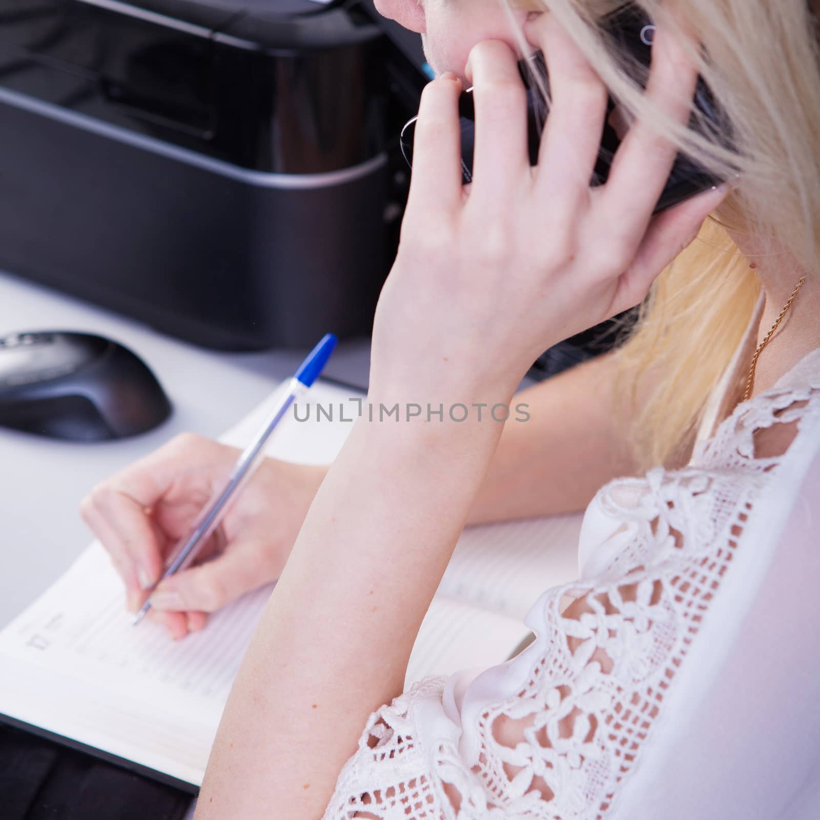 business woman talking on the phone at work and working on tablet