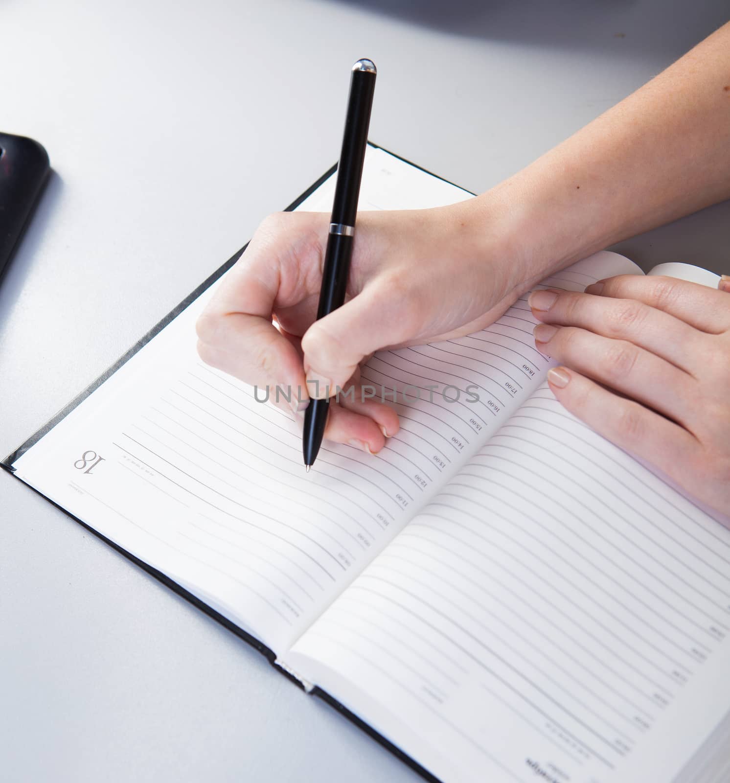 business woman in the workplace does records in a diary