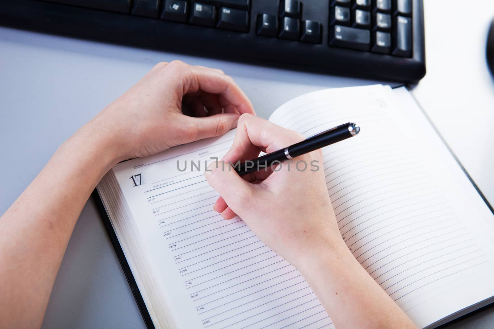 business woman in the workplace does records in a diary