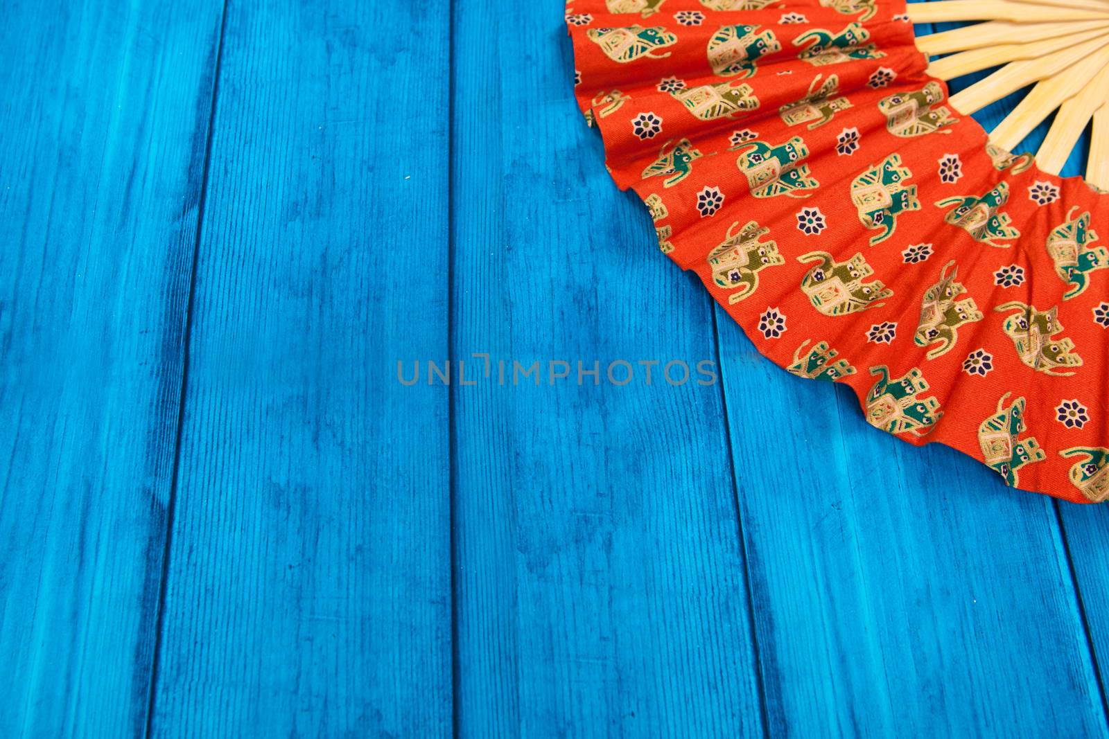 red fan on blue wooden background