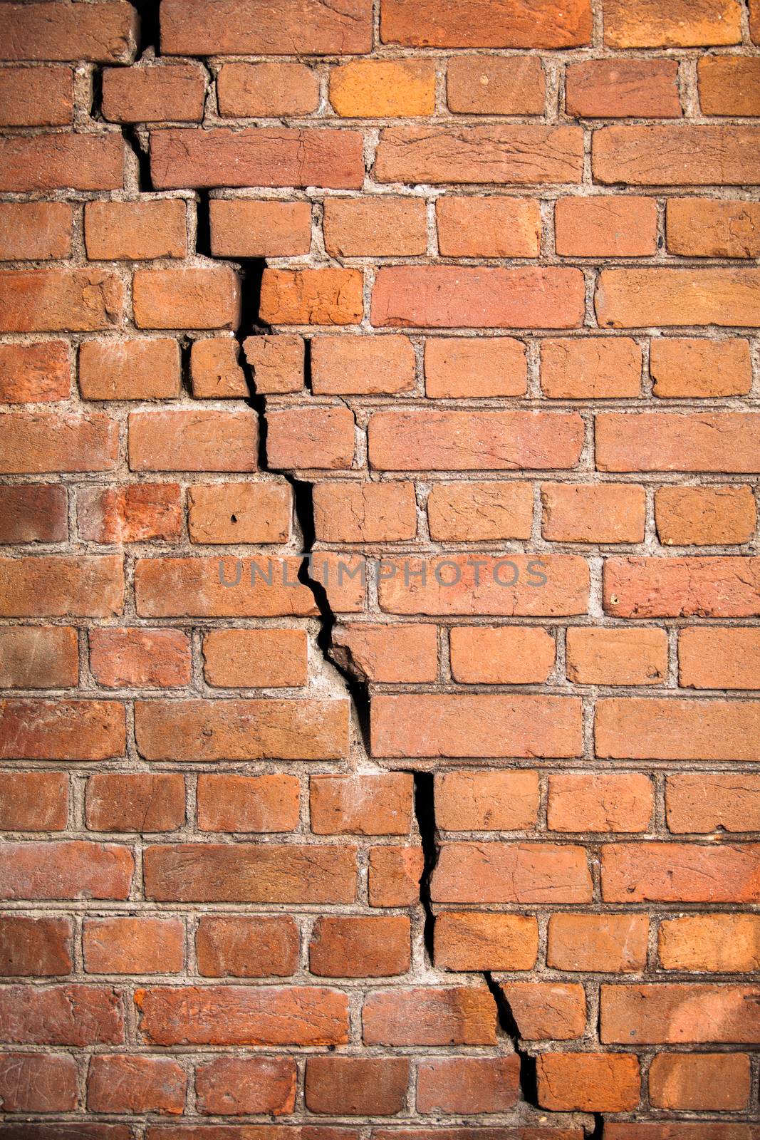 Background texture. The wall of the old red brick with a crack across the wall