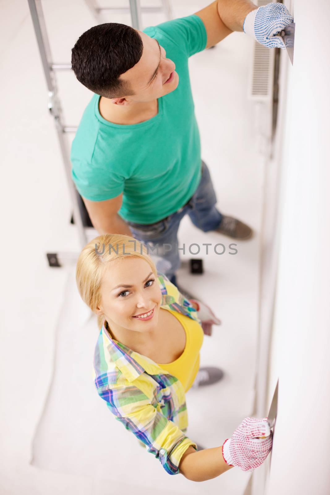 smiling couple doing renovations at home by dolgachov