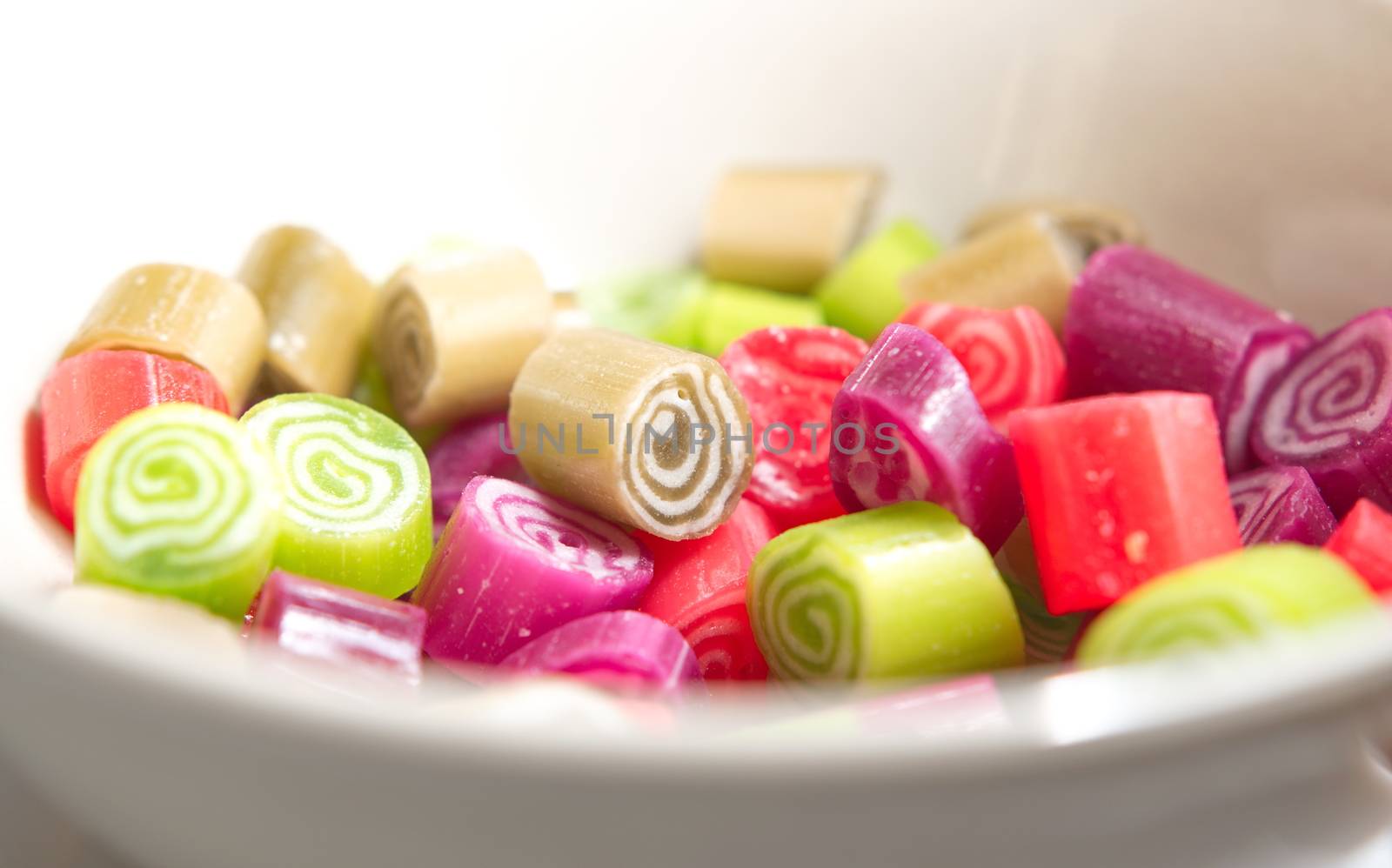 Colorful candies on white background by anderm