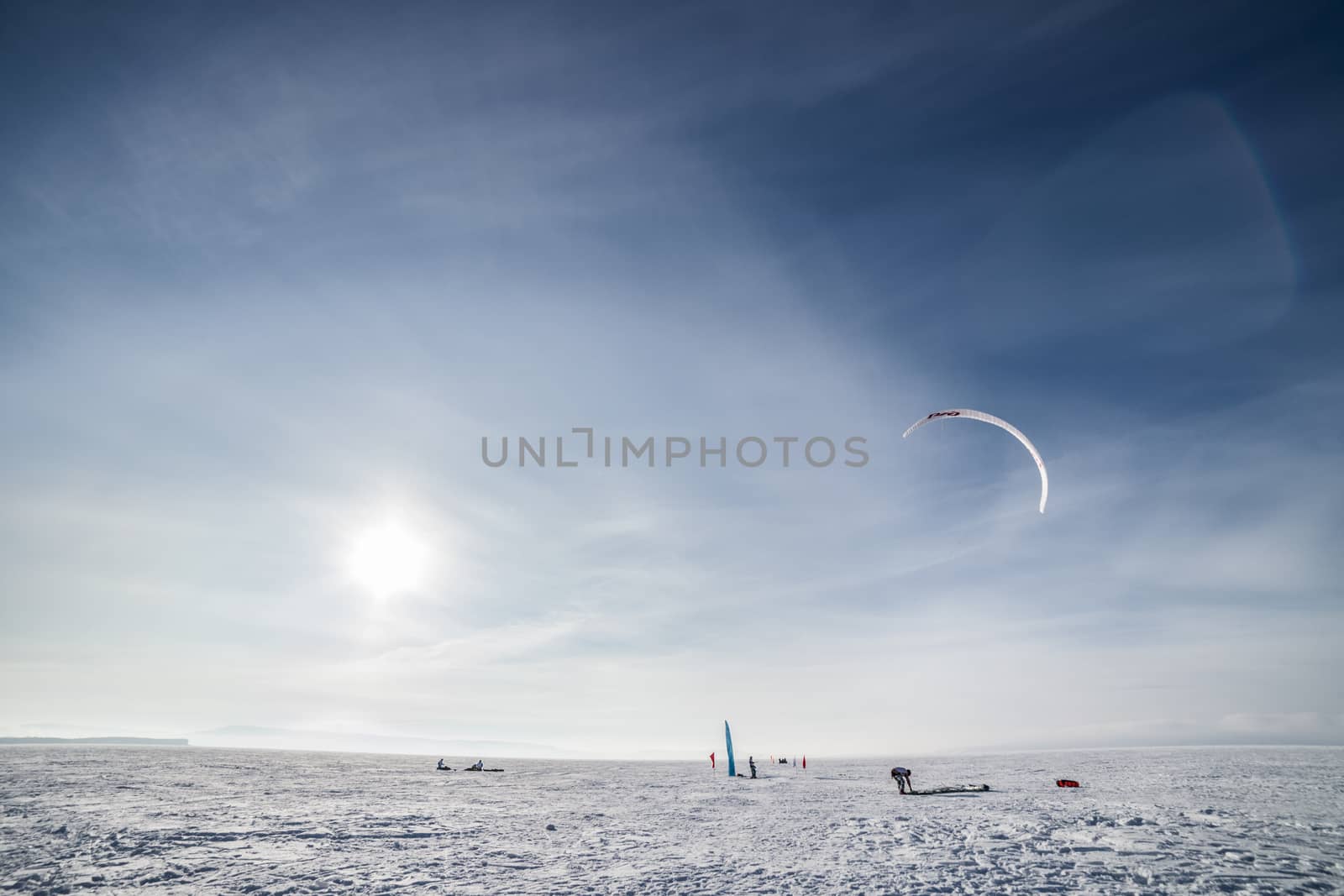 Kite surfer being pulled by his kite across the snow