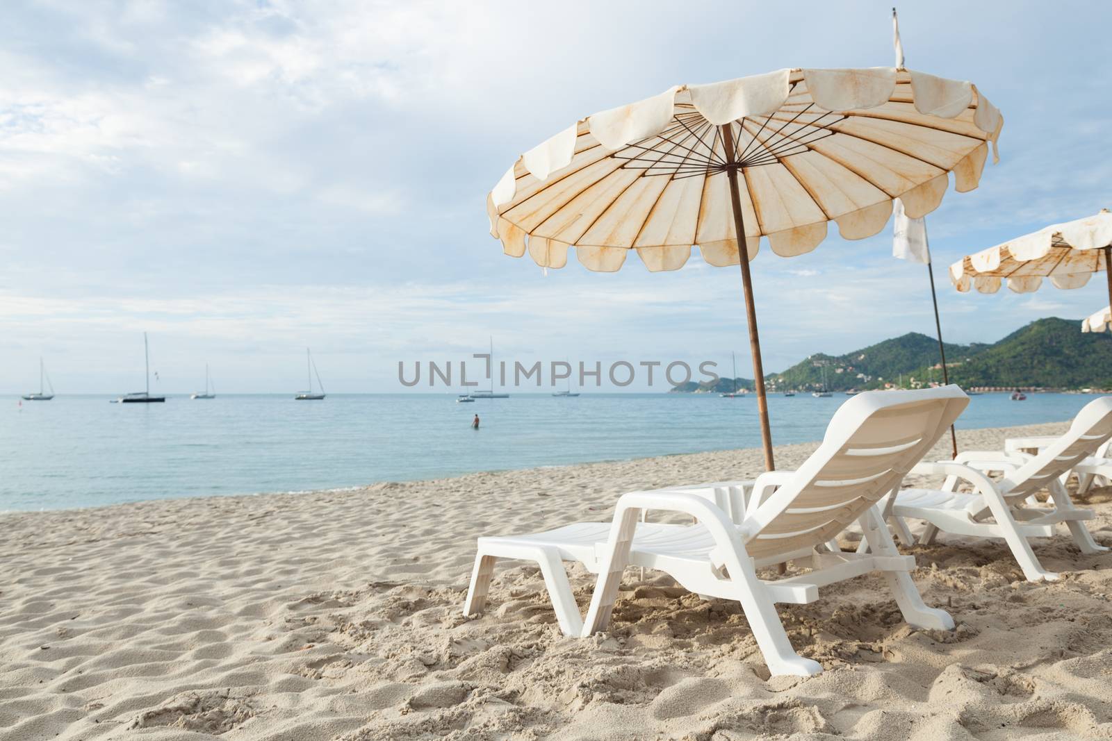 Beds and umbrellas on the beach. The seaside beach tourist attractions.