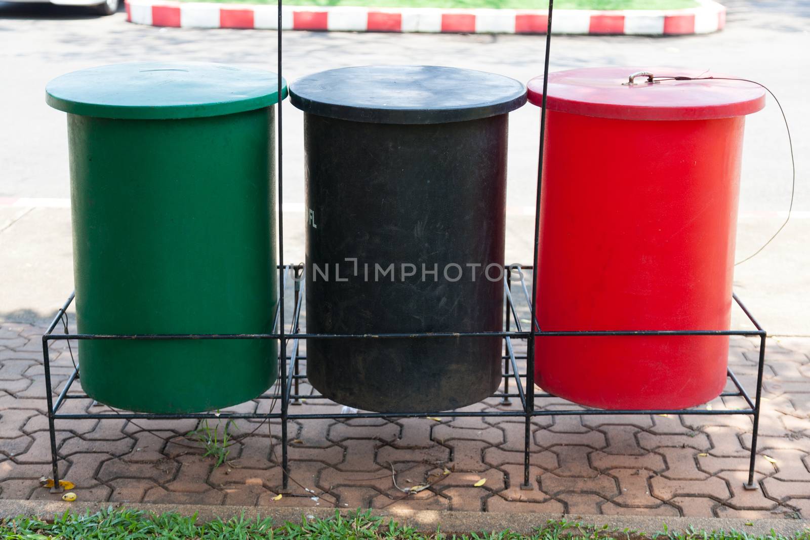 Colorful trash Located near the walkway in the park.