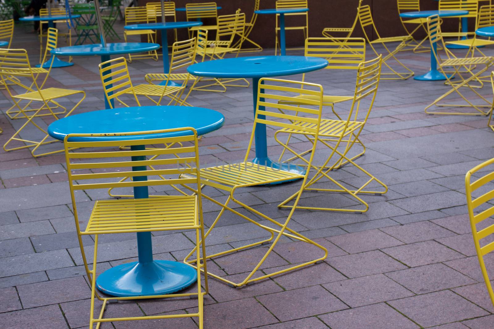 Close up of yellow chairs and blue tables