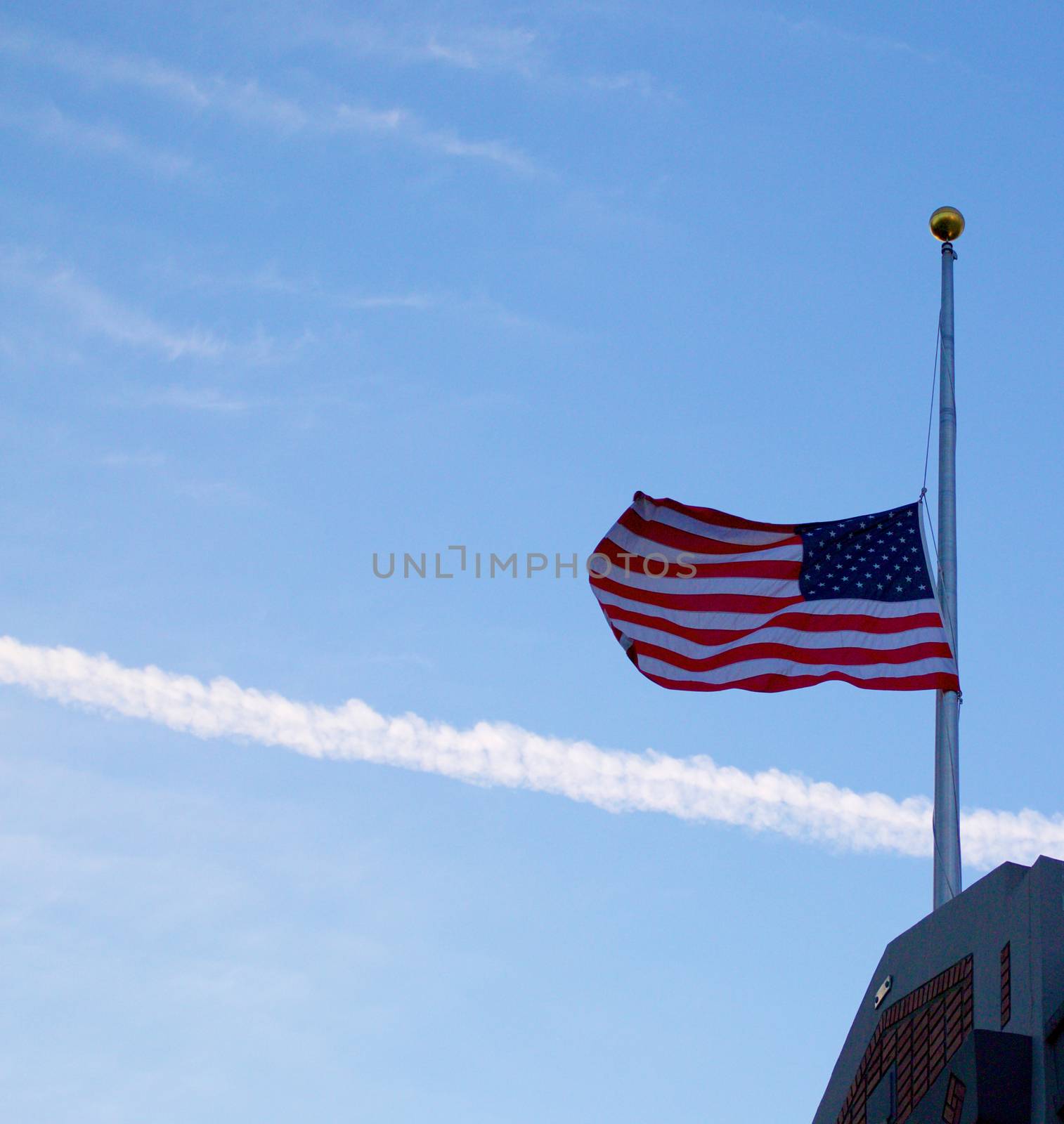US Flag at half mast on top of a building