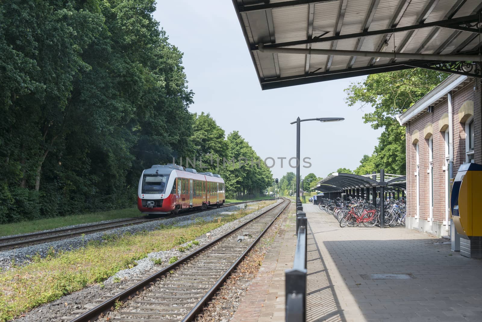 DELDEN,HOLLAND-JULY 4,2015: red train in holland crossing station of the city delden,Delden is the smallest station in the east part of delden still in use