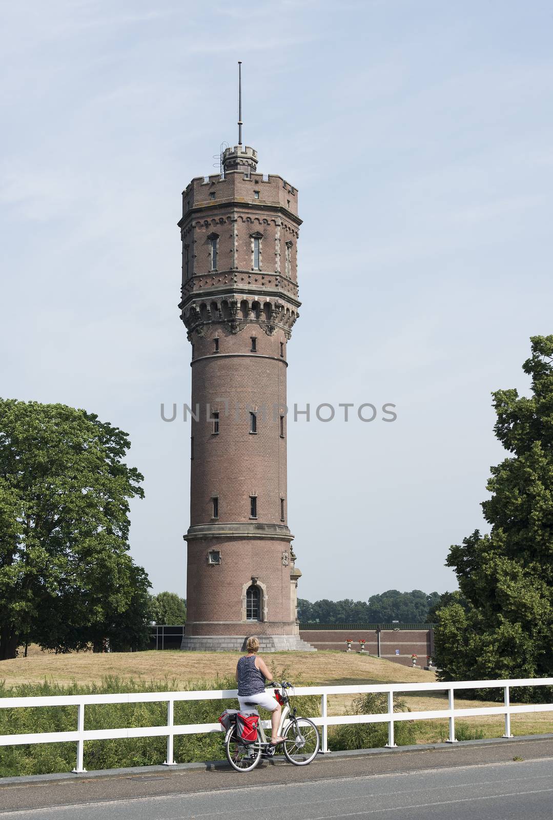 woman standing in front of water tower by compuinfoto