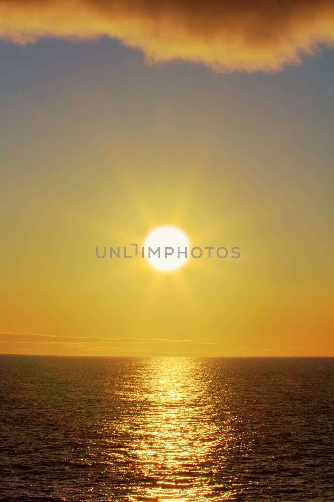 sun hangs over ocean in lower position in sky, polar day