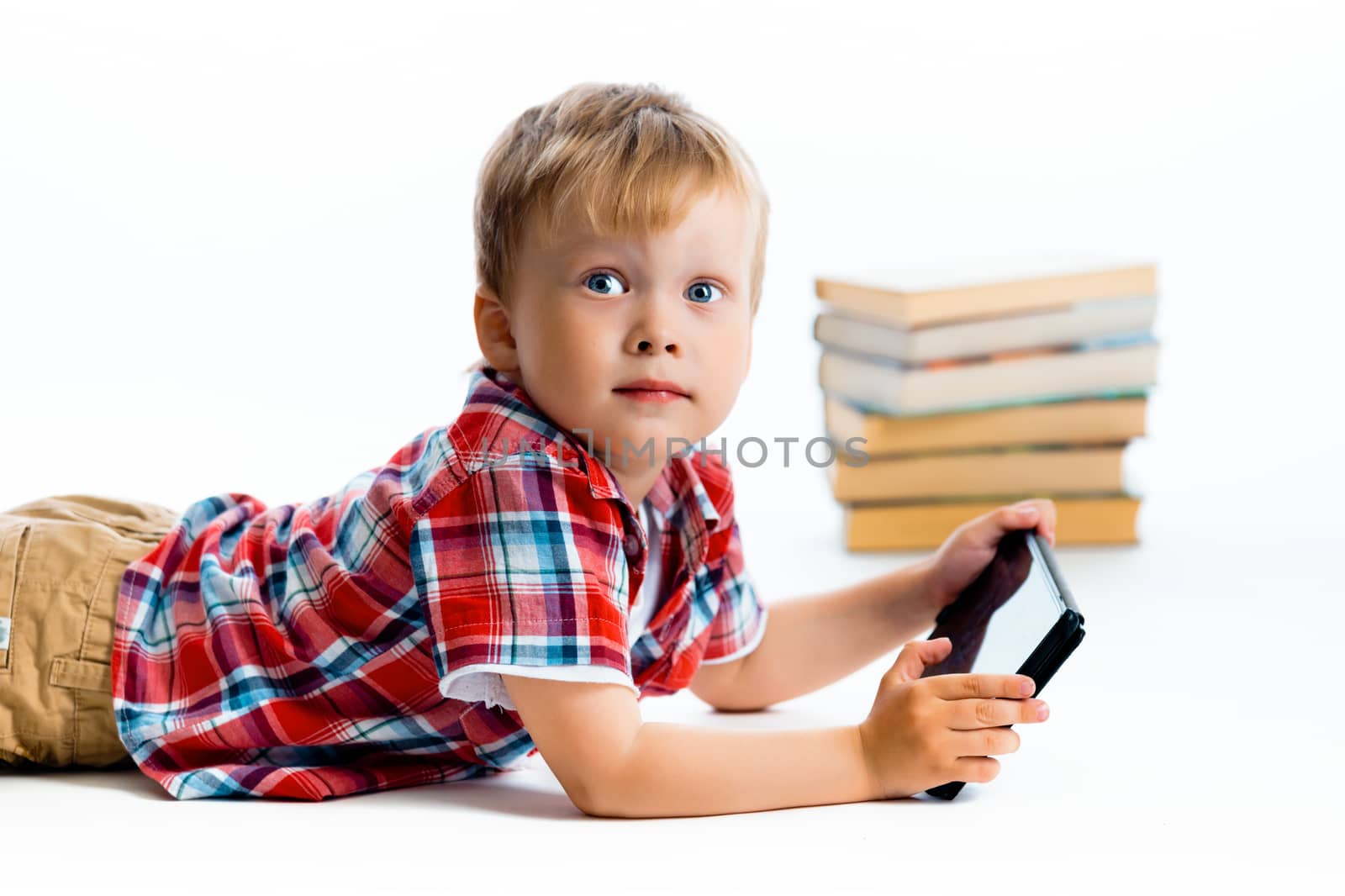 little boy in a plaid shirt with a tablet computer against a white background.
