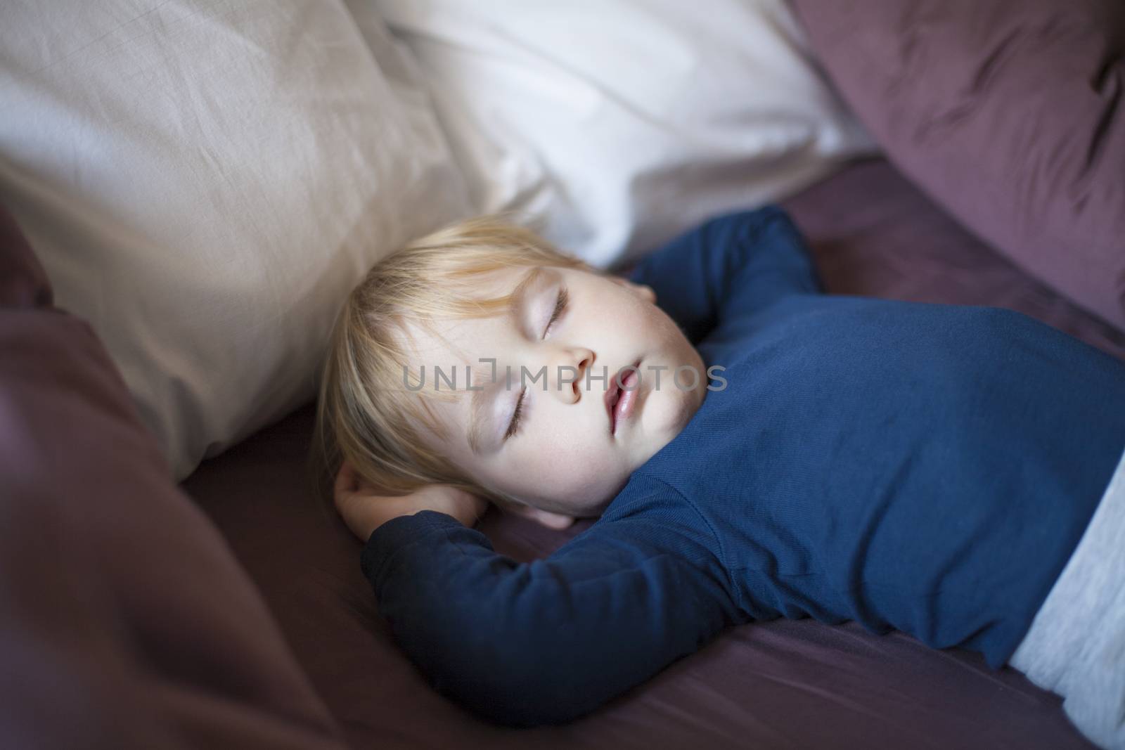 face baby sleeping between cushions by quintanilla