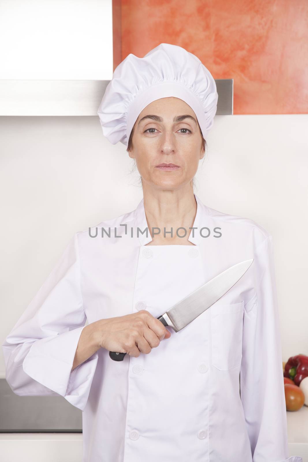 proud woman chef saluting knife on chest by quintanilla