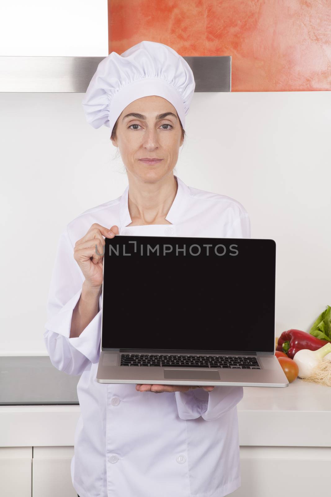 woman chef showing blank laptop by quintanilla