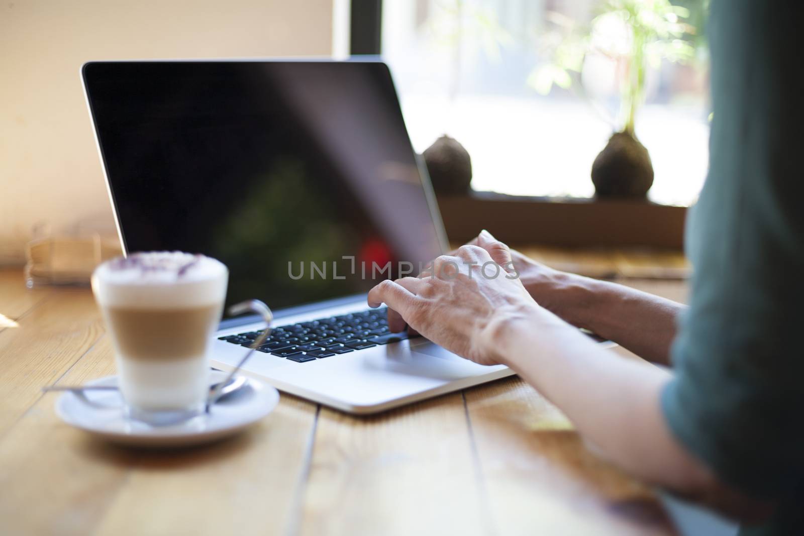 green shirt woman typing blank screen laptop by quintanilla