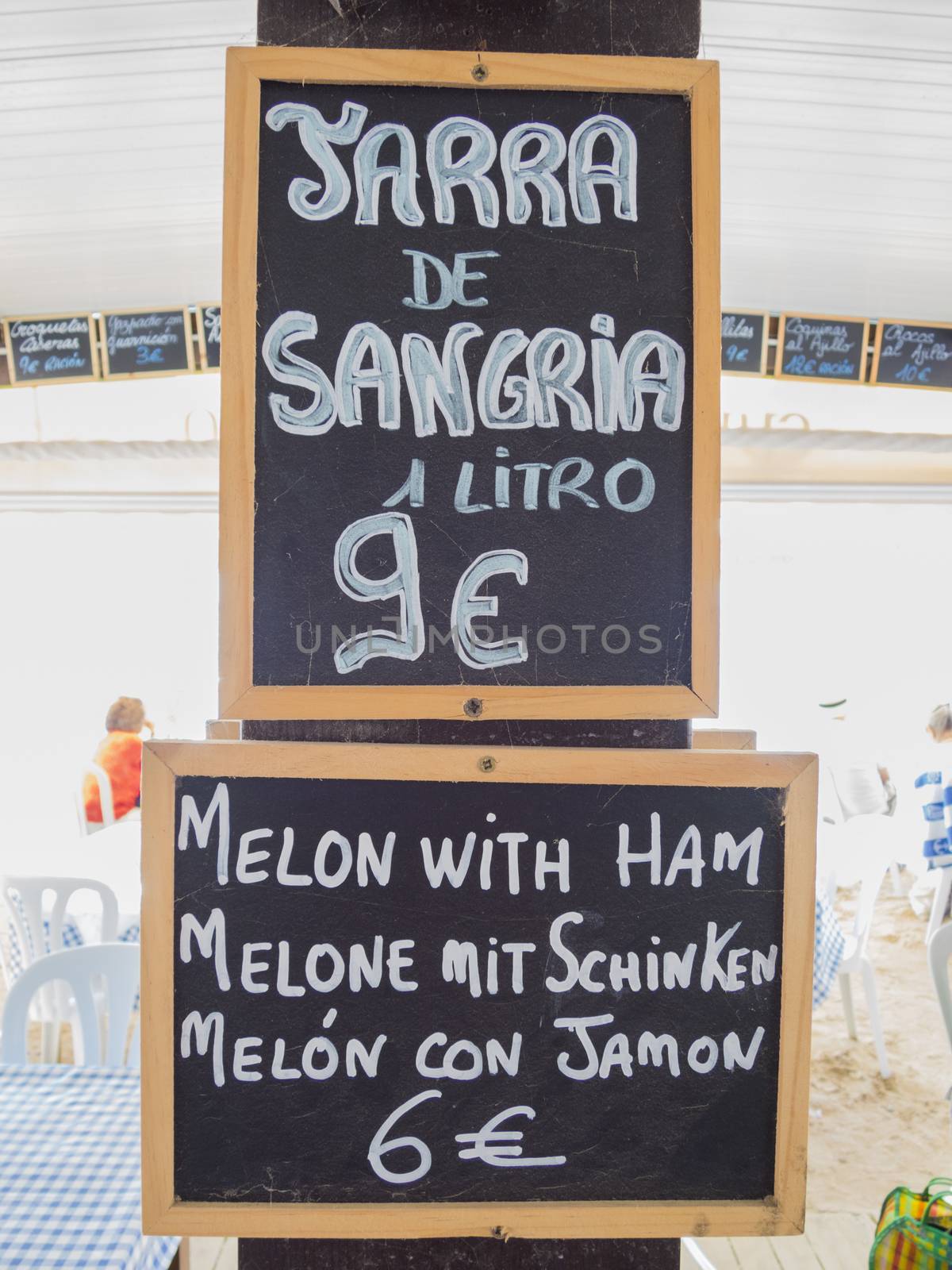 black placard spanish white handwritten in wall with typical menu food dishes in Spain restaurant like sangria and melon ham