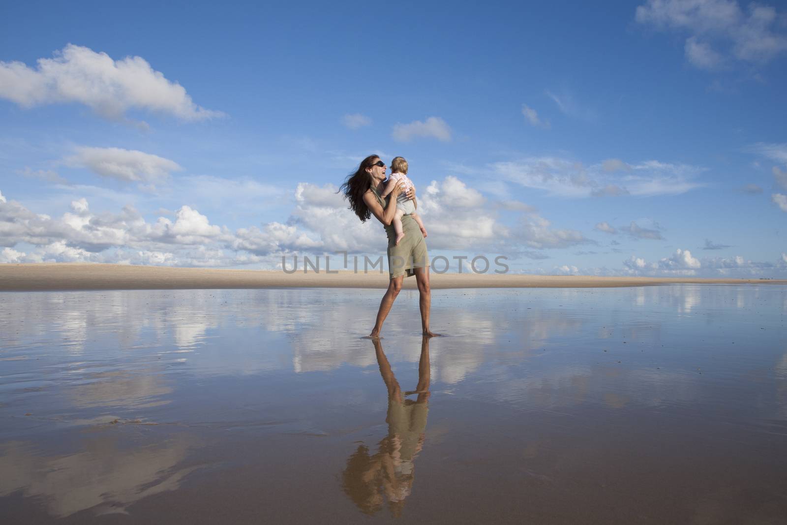 woman with baby at reflect beach by quintanilla