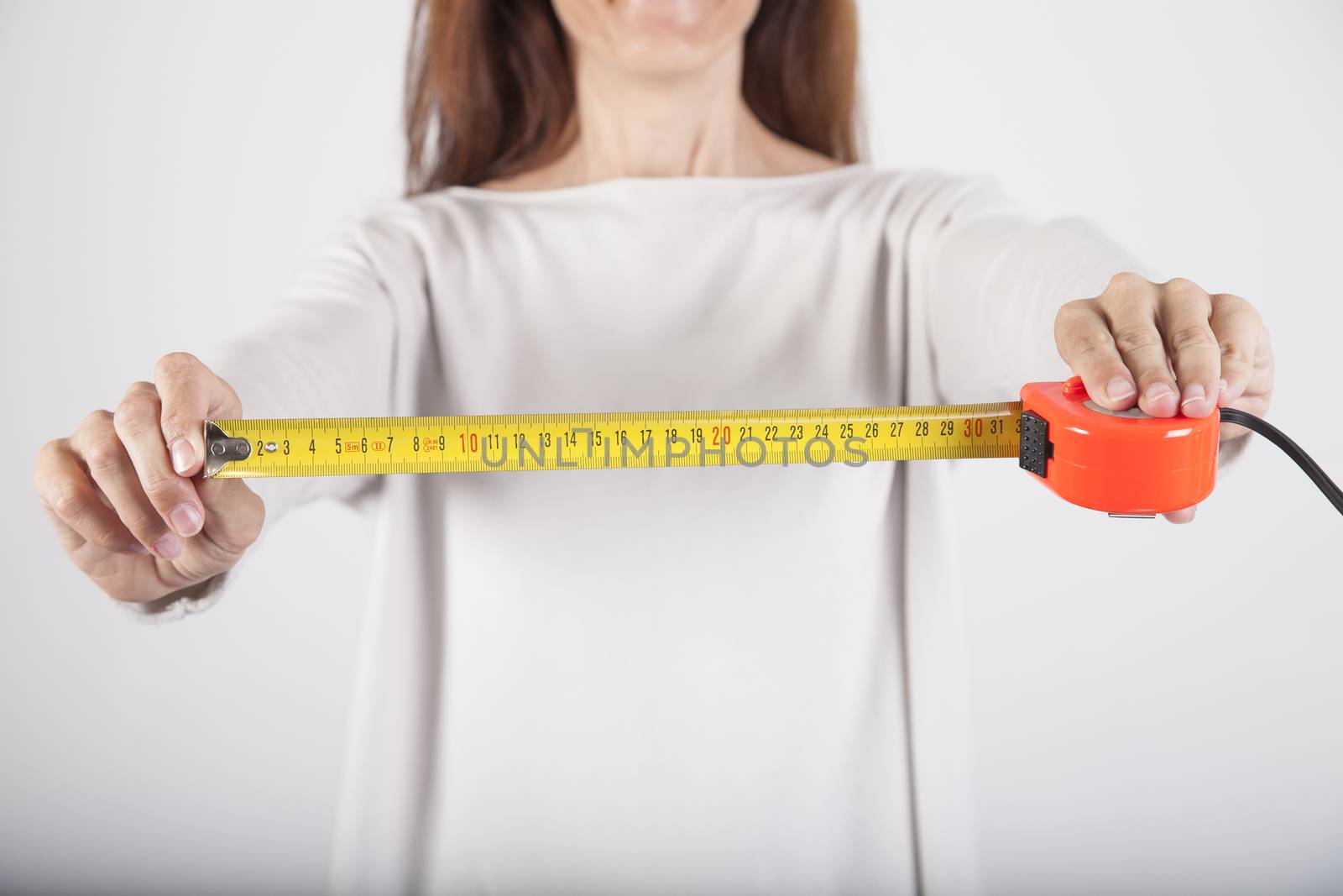 yellow open measure tape in woman hand fingers isolated over white background