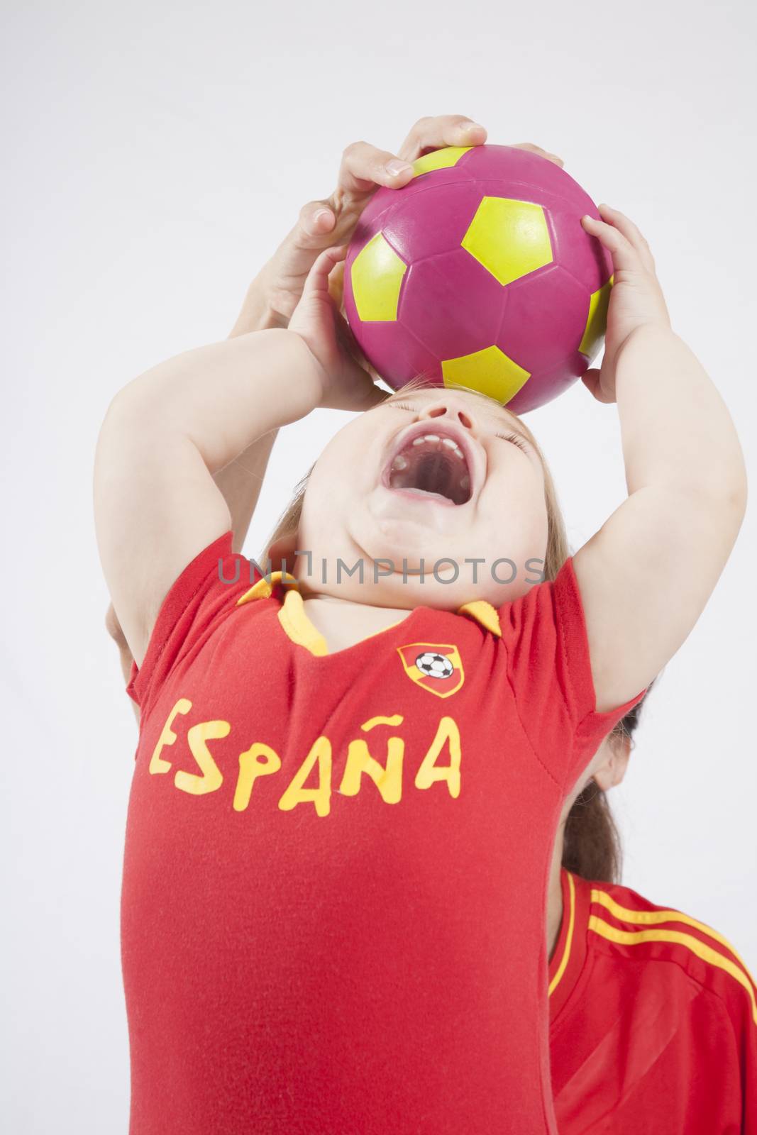 blonde baby sixteen month old and mother with red shirt of Spanish soccer team taking ball