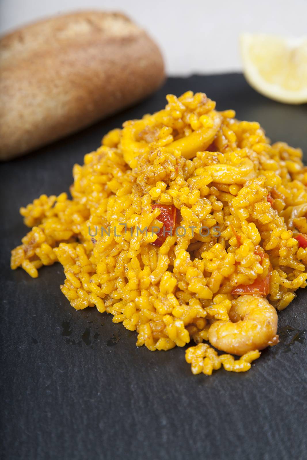 close up detail of spanish paella on black plate