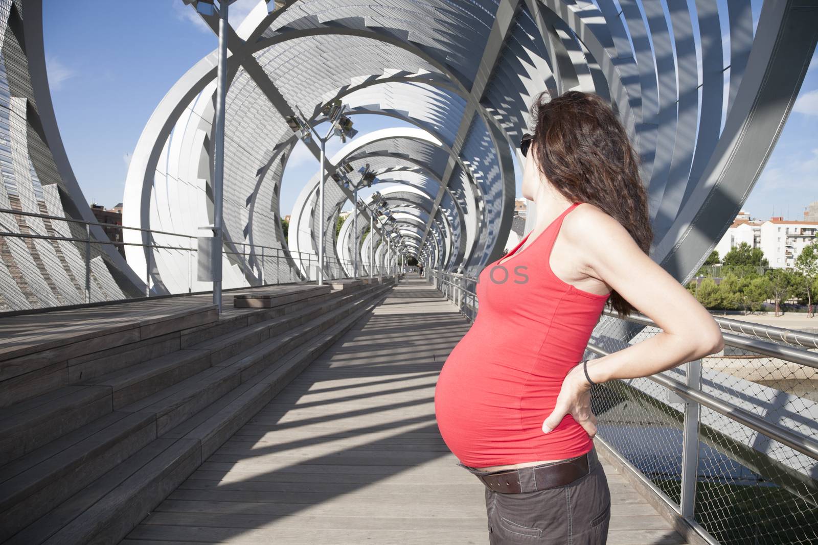 pregnant woman with red shirt at Madrid bridge