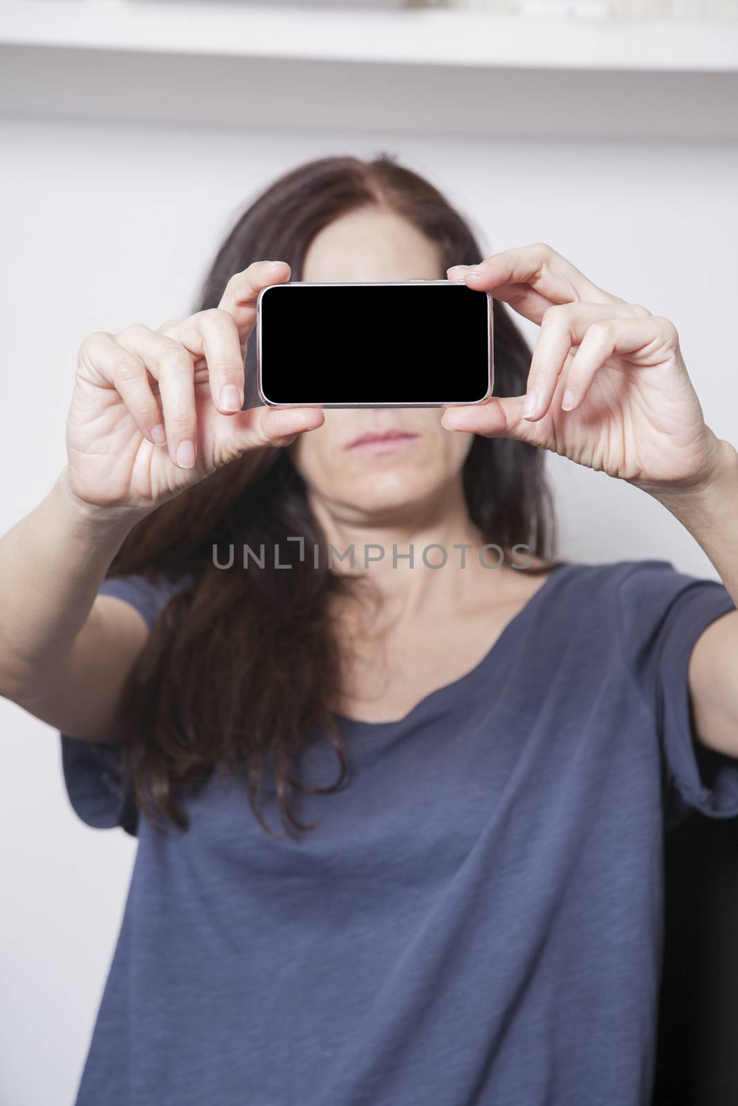 blank black screen smartphone close on blue shirt woman hands