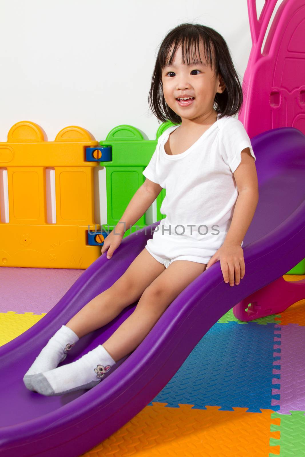 Asian Chiense girl sliding at indoor playground