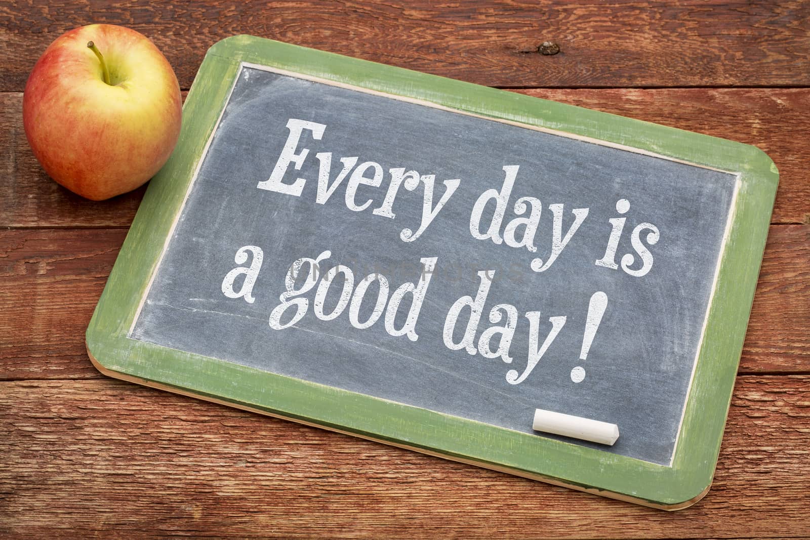 Every day is good day - positive words on a slate blackboard against red barn wood
