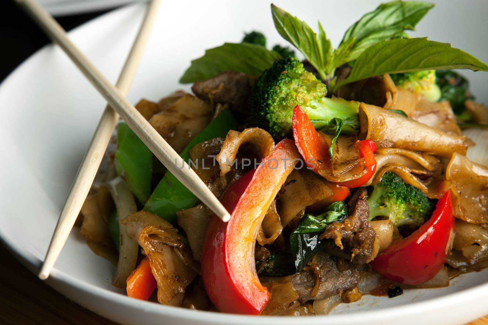 Pad kee mao drunken noodle thai dish with beef and mixed vegetables.