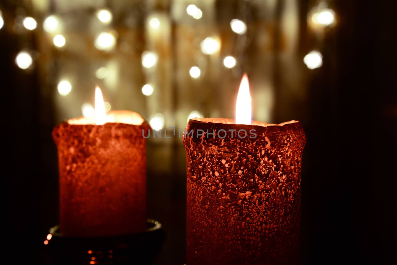 Two orange candles over christmas lights by dk_photos