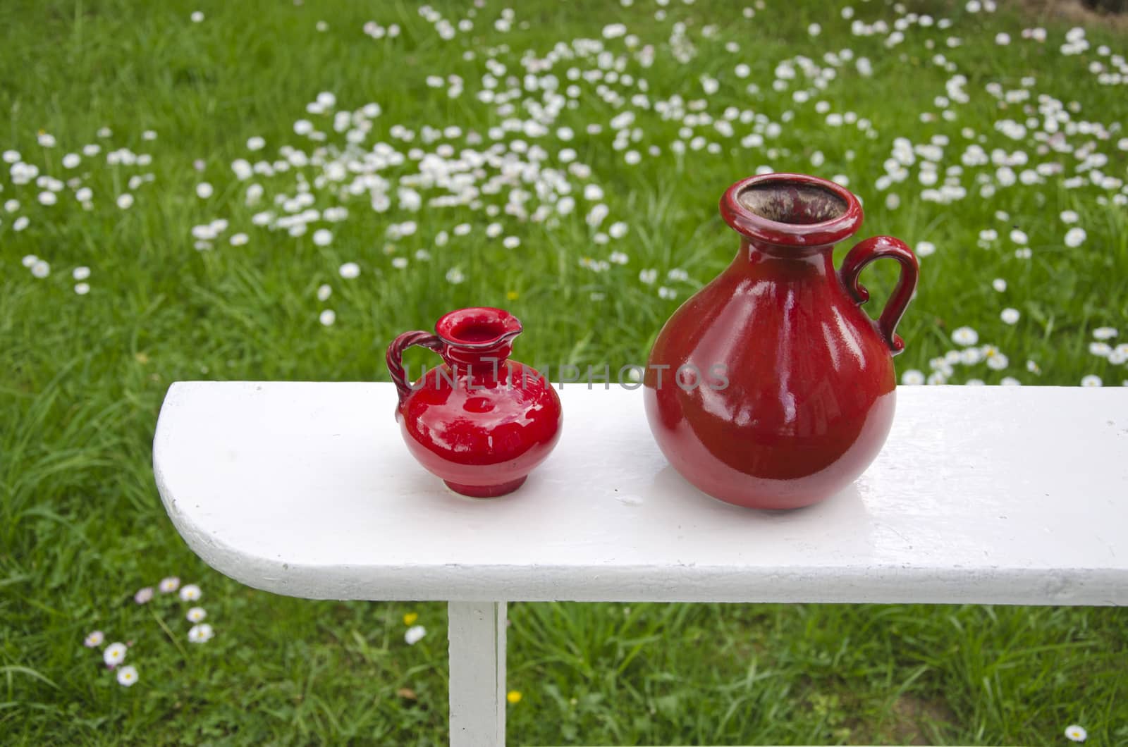two red ceramic jug on garden wooden white shelf