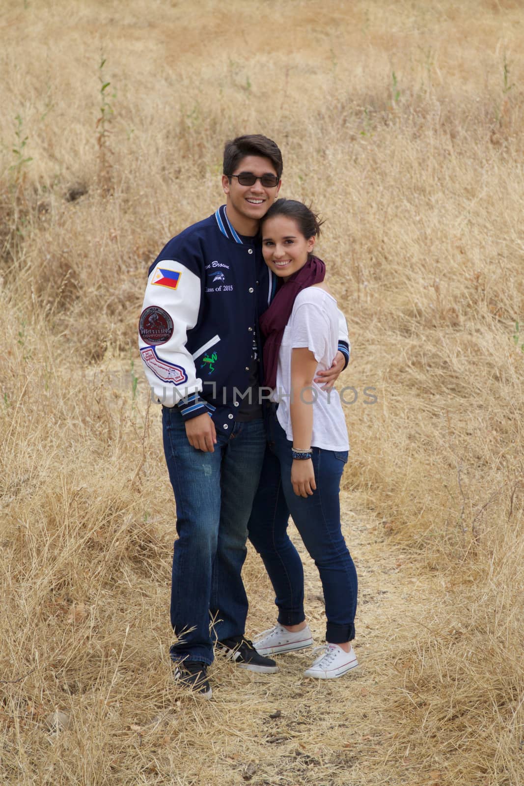 Happy teen couple standing in a meadow