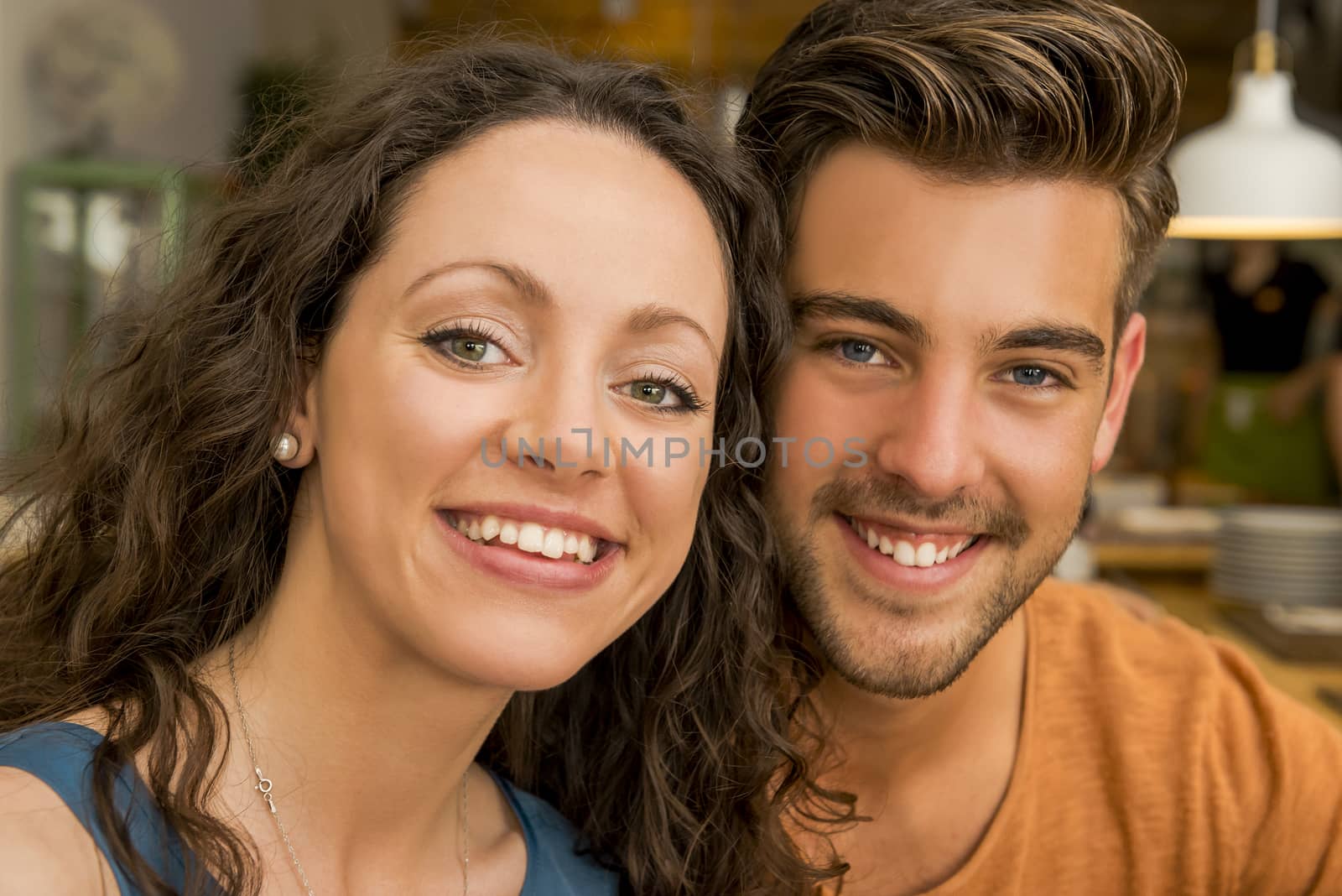 Happy couple at the restaurant talking and smiling