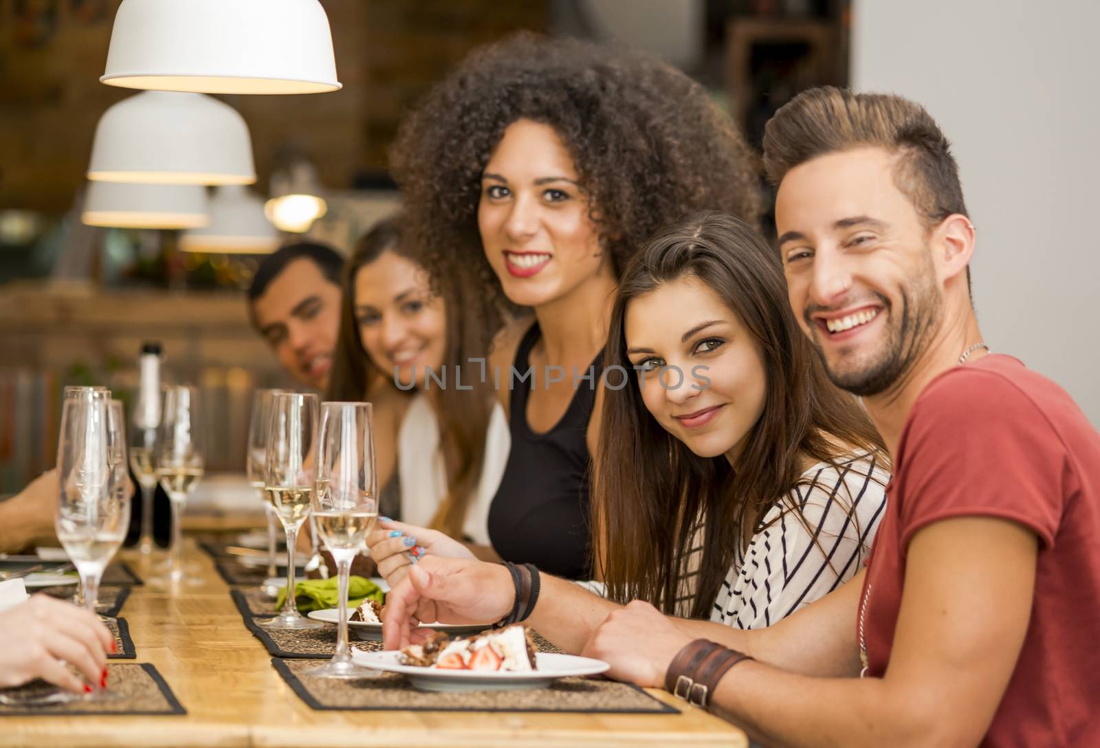 Multi-Ethnic Group of happy friends lunching and having fun at the restaurant