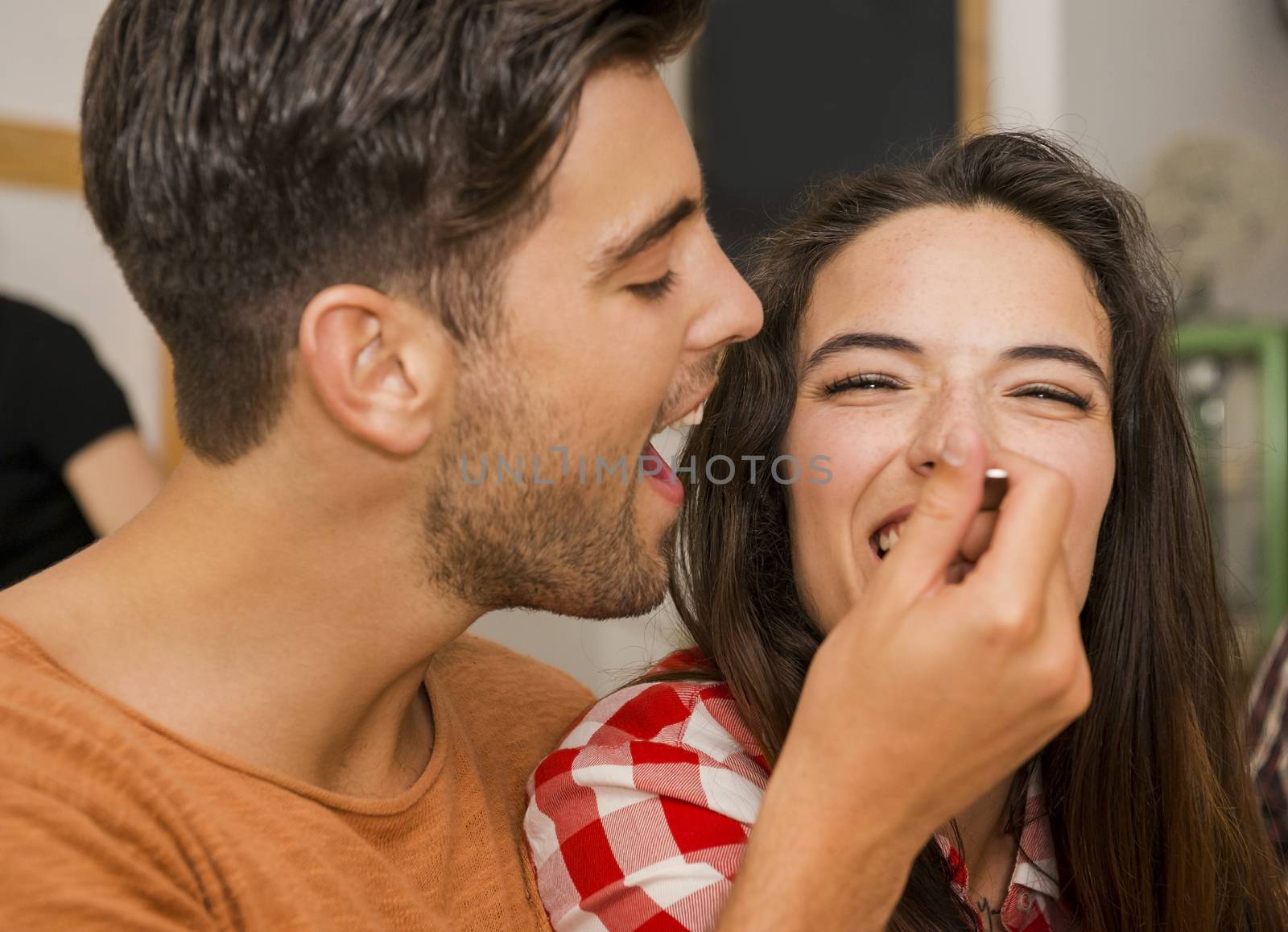 Happy couple at the restaurant and giving food in mouth