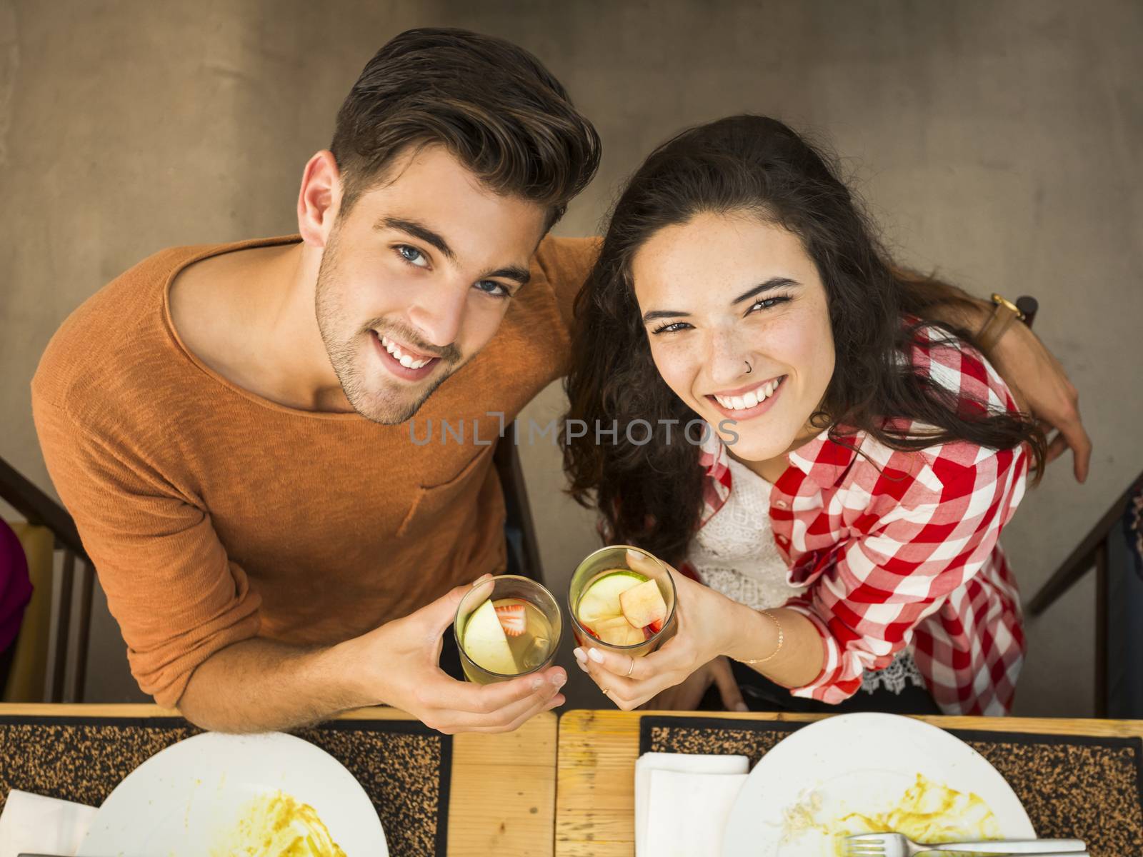 Young couple toasting and looking happy at a restaurant