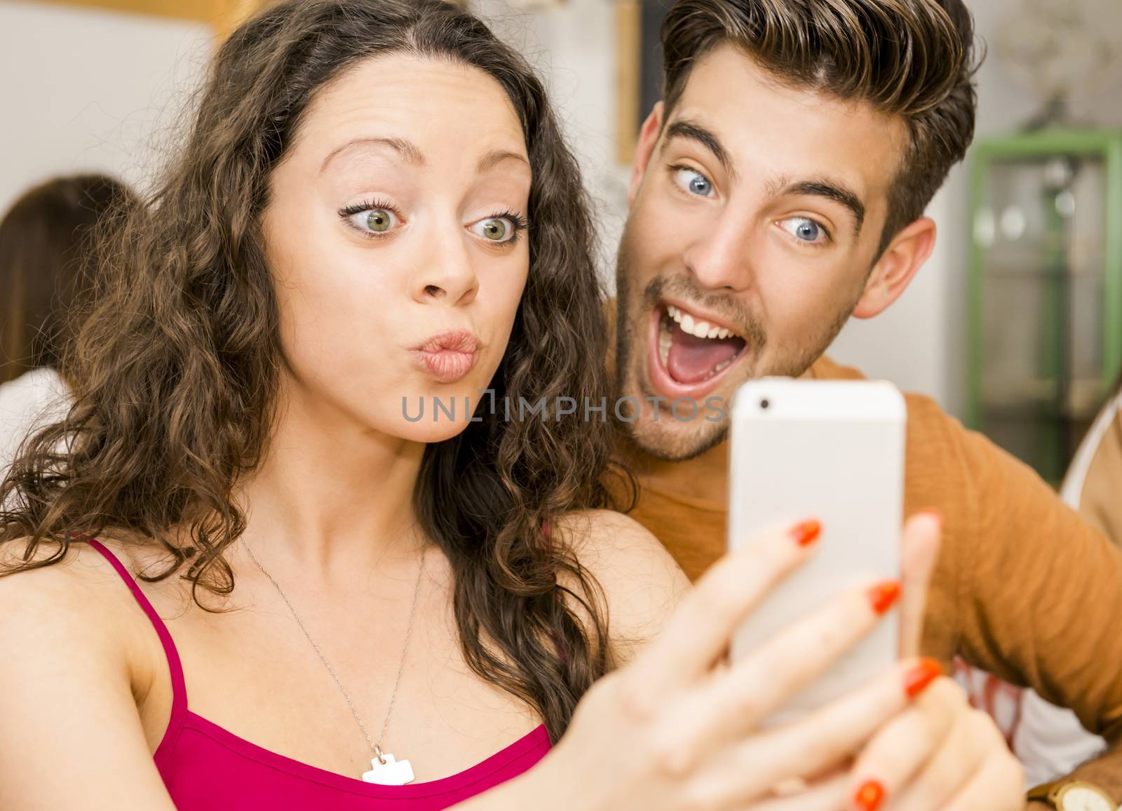 Happy couple at the restaurant making a selfie