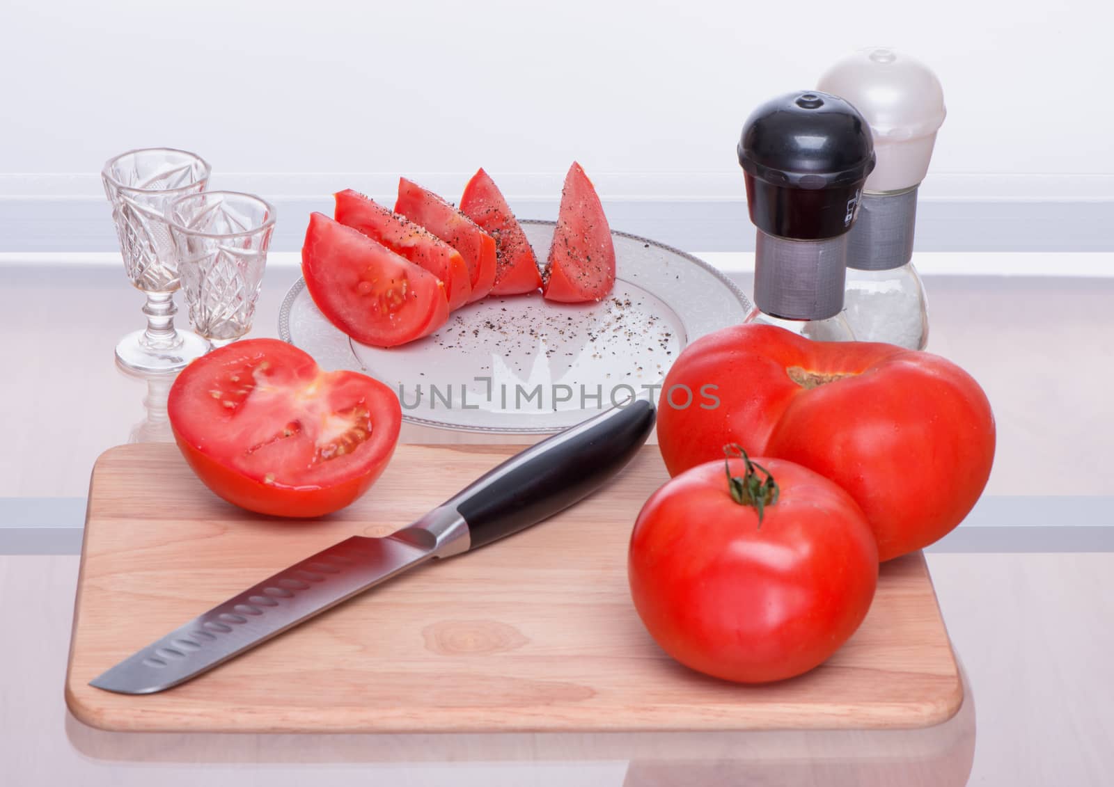 Tomatoes and knife on a chopping board by fotooxotnik