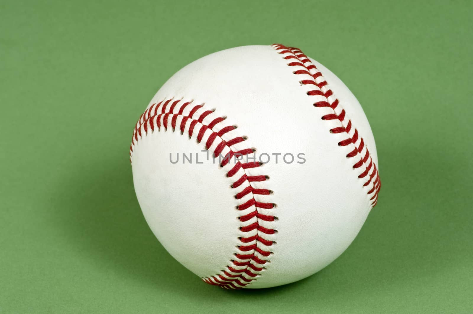Close up shot of a new baseball shot on green background