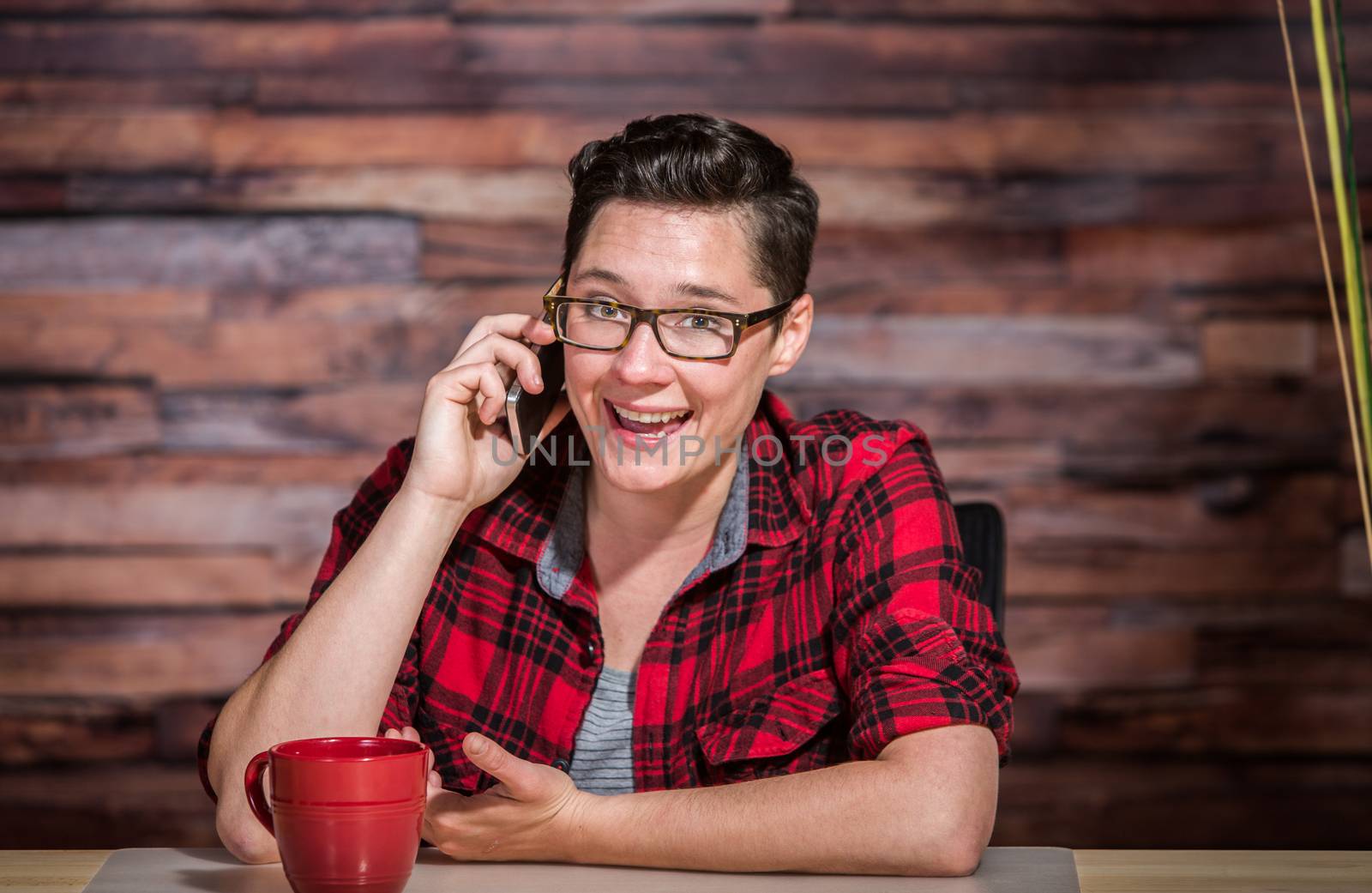 Enthusiastic woman in business casual outfit on phone