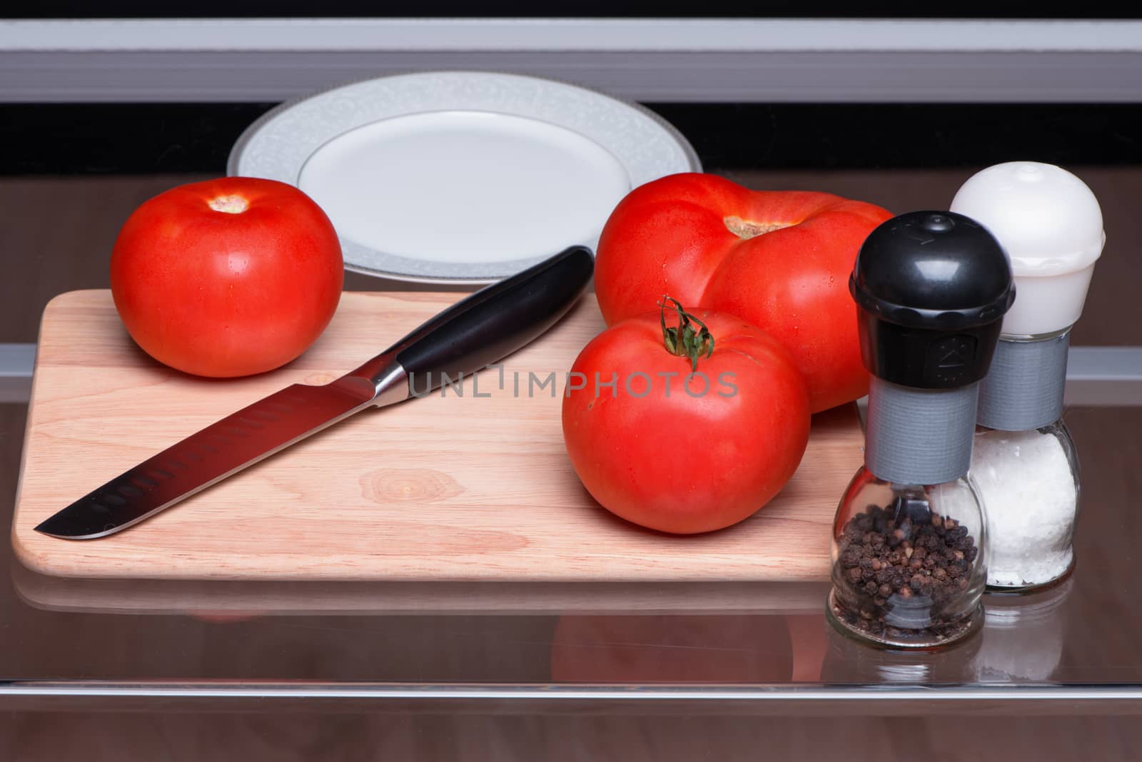 Tomatoes and knife on a chopping board by fotooxotnik