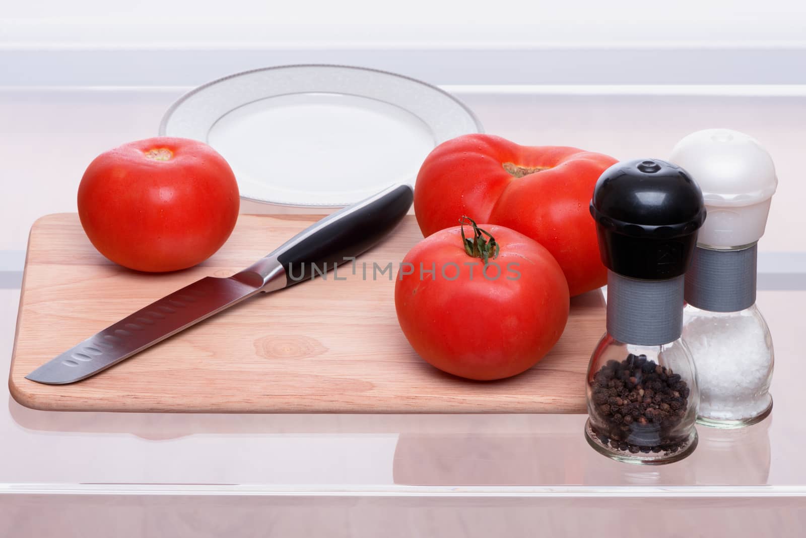 Tomatoes and knife on a chopping board by fotooxotnik