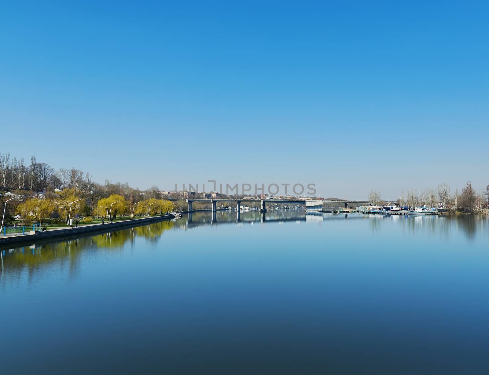 deep blue sky over river with bridge by mycola