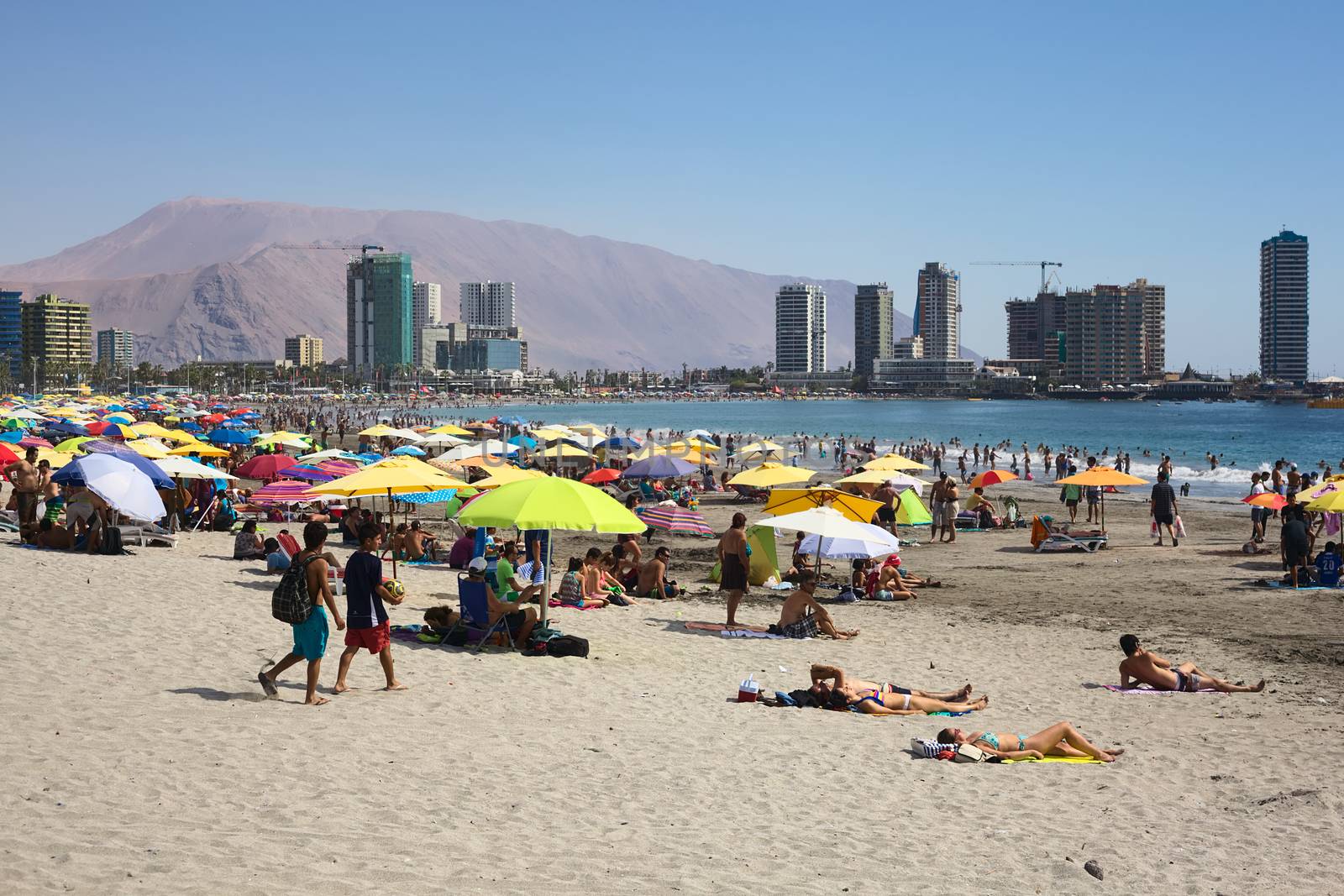 IQUIQUE, CHILE - JANUARY 23, 2015: Unidentified people enjoying the summer on the crowded Cavancha beach on January 23, 2015 in Iquique, Chile. Iquique is a popular beach town and free port city in Northern Chile.  