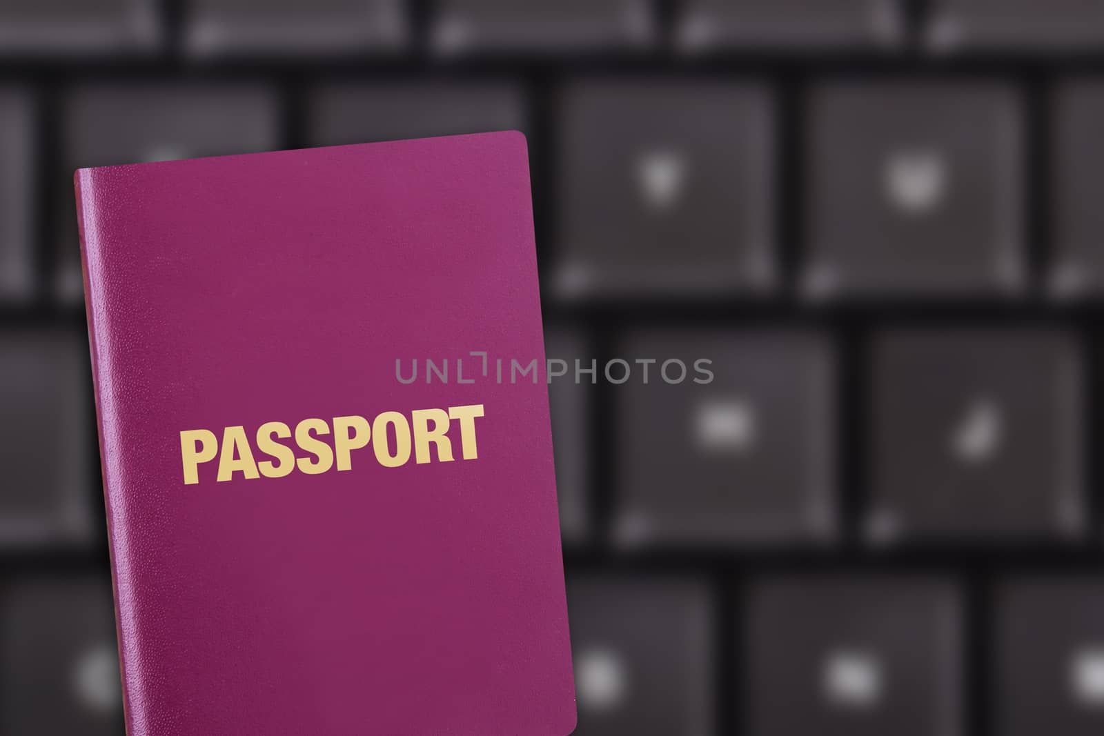 Close up detailed front view of a passport on blury keyboard as background.