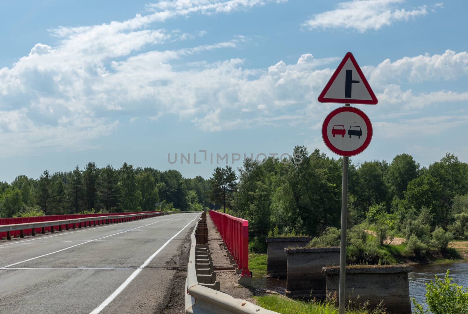 two signs on the road before the bridge